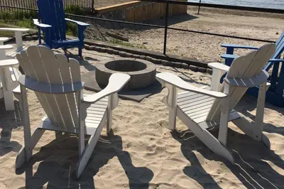 three chairs and a fire pit in the sand at The Driftwood Deck 5A in Wasaga Beach