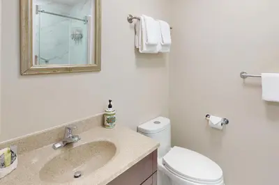 a bathroom with a sink and a toilet and a mirror at The Driftwood Deck 5A in Wasaga Beach
