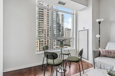 a living room with a table and chairs in front of a window at Spacious 2BR Condo Downtown, Lakeshore, Parking in Toronto