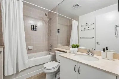 a bathroom with a toilet and a tub and a sink at Spacious 2BR Condo Downtown, Lakeshore, Parking in Toronto