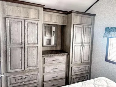 a bedroom with wooden cabinets and a mirror at Bobcaygeon Shores Cottage Resort in Kawartha Lakes