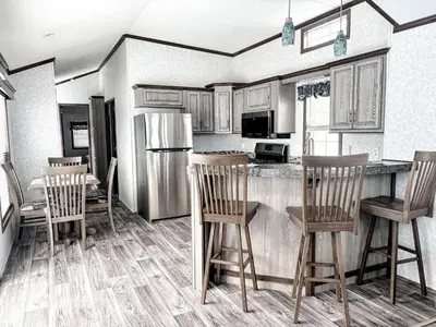 a kitchen with a refrigerator and a table and chairs at Bobcaygeon Shores Cottage Resort in Kawartha Lakes