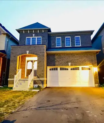 a house with two garage doors and a driveway at 15 mins from Niagara falls-5 Bedrooms Inn in Thorold