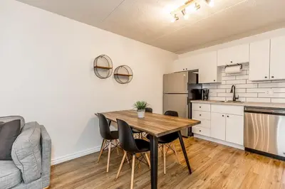 a kitchen and dining room with a wooden table and chairs at The Landing Pad - Condo in Collingwood in Collingwood
