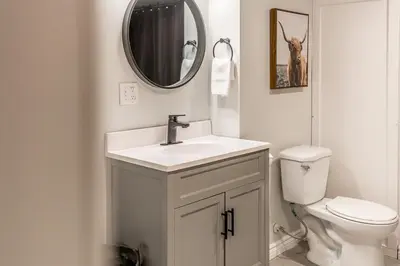 a bathroom with a sink and a toilet and a mirror at The Landing Pad - Condo in Collingwood in Collingwood