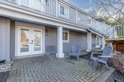 two chairs sitting on a patio in front of a house at The Landing Pad - Condo in Collingwood in Collingwood