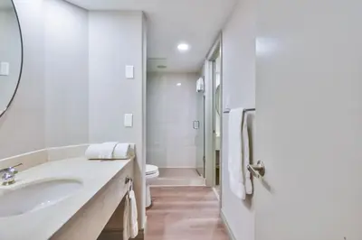 a white bathroom with a sink and a toilet at Highland Hideaway 1BR King Suite in Shanty Bay