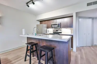 a kitchen with a counter and two stools at Highland Hideaway 1BR King Suite in Shanty Bay