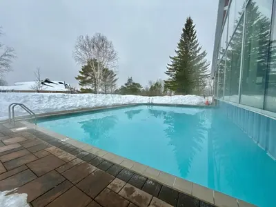 a swimming pool covered in snow next to a building at King Suite heated Pool Sauna and Kitchen in Shanty Bay