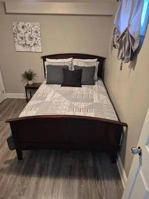 a large bed in a bedroom with wooden floors at Whitby one bedroom apartment in Whitby
