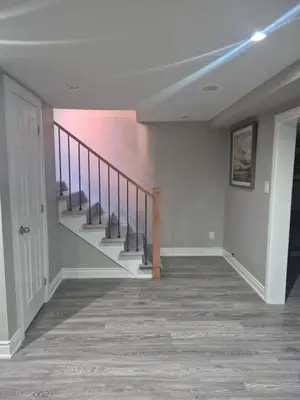 an empty hallway with stairs in a home at Whitby one bedroom apartment in Whitby