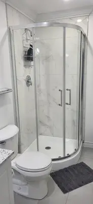 a white bathroom with a shower and a toilet at Entire Studio Guest Suite in Kitchener in Kitchener