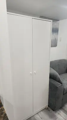 a white cabinet in a living room with a couch at Entire Studio Guest Suite in Kitchener in Kitchener