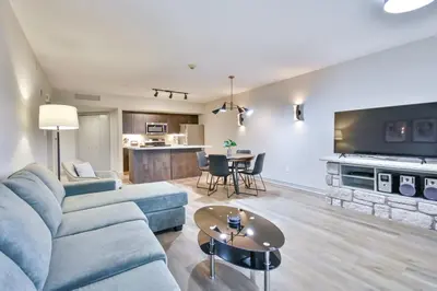 a living room with a blue couch and a table at Hideaway 2BR Condo Pool & Heated Pool in Shanty Bay