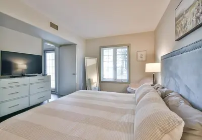 a bedroom with a large bed and a tv at Hideaway 2BR Condo Pool & Heated Pool in Shanty Bay