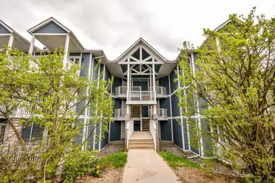 an exterior view of a blue house with trees at Hideaway 2BR Condo Pool & Heated Pool in Shanty Bay