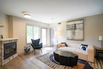 a living room with a couch and a fireplace at Lower Level LuxSuite - 1min Walk from Heated Pool! in Shanty Bay