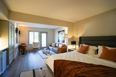 a bedroom with a large bed and a living room at Lower Level LuxSuite - 1min Walk from Heated Pool! in Shanty Bay