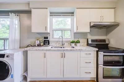 a kitchen with white cabinets and a sink at Nest in the Orchard--cozy room in Toronto