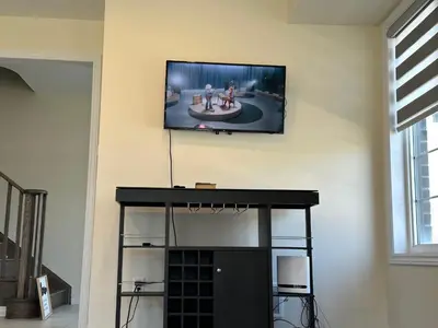 a flat screen tv hanging on a wall at World Cup Soccer Fans Stay! Luxury 4BR Family Retreat in Thorold, Just 10 Mins Niagara Falls, Clifton Hill & Wineries Free Wi-Fi, Free Parking in Thorold