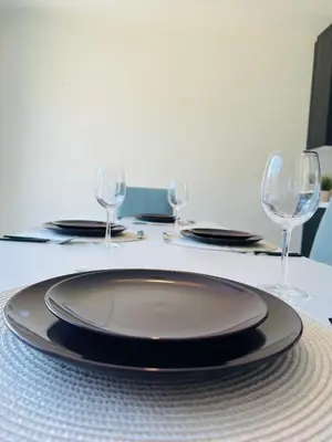 a table with a plate and wine glasses on it at World Cup Soccer Fans Stay! Luxury 4BR Family Retreat in Thorold, Just 10 Mins Niagara Falls, Clifton Hill & Wineries Free Wi-Fi, Free Parking in Thorold