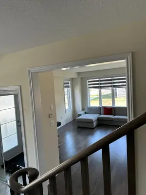 a living room with a couch and a mirror at World Cup Soccer Fans Stay! Luxury 4BR Family Retreat in Thorold, Just 10 Mins Niagara Falls, Clifton Hill & Wineries Free Wi-Fi, Free Parking in Thorold
