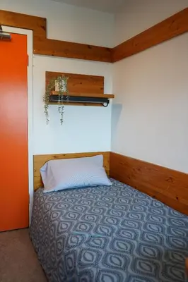 a bedroom with a bed with a white pillow at Tartu College Student Residence in Toronto