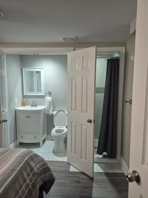 a bedroom with a bathroom with a toilet and a sink at Two bedroom basement apartment in Whitby