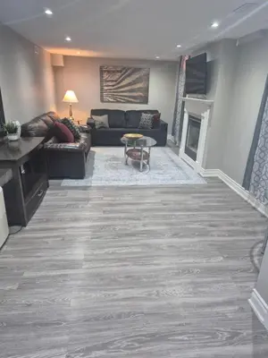 a living room with a couch and a fireplace at Two bedroom basement apartment in Whitby