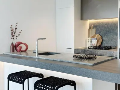 a kitchen with a sink and two black stools at INFIVILLA King Suites & Towers Soho Toronto in Toronto