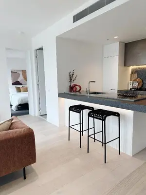 a kitchen and living room with a counter and stools at INFIVILLA King Suites & Towers Soho Toronto in Toronto