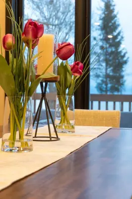 three vases with red flowers sitting on a table at Luxurious waterfront cottage in Bowmanville