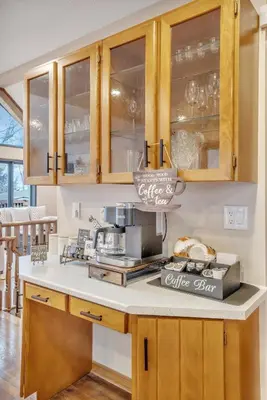 a kitchen with wooden cabinets and a coffee station at Luxurious waterfront cottage in Bowmanville