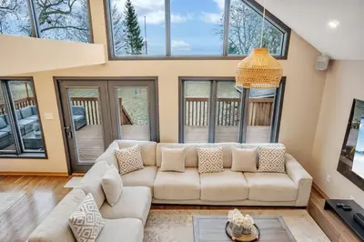 a living room with a couch and windows at Luxurious waterfront cottage in Bowmanville
