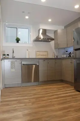 a kitchen with stainless steel appliances and wooden floors at Queen Bed Suite-Private Entrance in Barrie