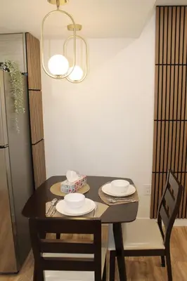 a dining room table with two chairs and a black table with plates at Queen Bed Suite-Private Entrance in Barrie
