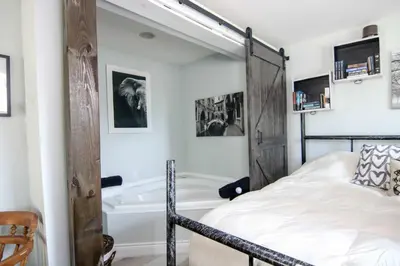 a bedroom with a bed and a bath tub at The Jypsy Inn - Tuxedo Room Muskoka in Bracebridge