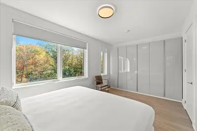 a bedroom with a large white bed and a window at Luxury Muskoka Retreat in Gravenhurst