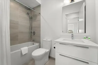 a white bathroom with a toilet and a sink at Luxury Muskoka Retreat in Gravenhurst