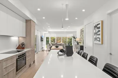 a kitchen and living room with a large white table at Luxury Muskoka Retreat in Gravenhurst