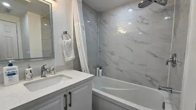 a bathroom with a tub and a sink and a shower at Cozy 1BR Garden Suite Innisfil Beach Park in Innisfil