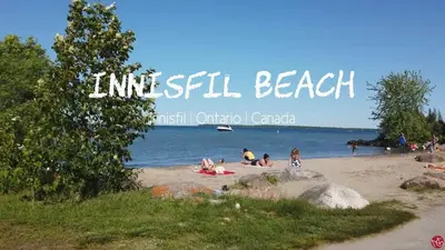 a group of people sitting on a beach at Cozy 1BR Garden Suite Innisfil Beach Park in Innisfil