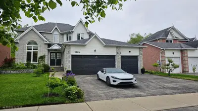 a white car parked in front of a house at Cozy 1BR Garden Suite Innisfil Beach Park in Innisfil