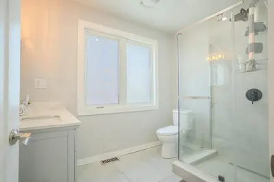 a white bathroom with a shower and a toilet at Wonderful house in Niagara on the Lake