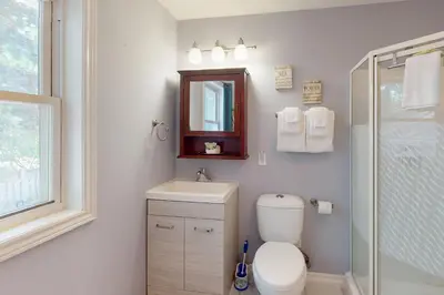 a bathroom with a toilet and a sink and a mirror at Wavy Daze in Wasaga Beach