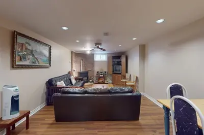 a living room with a black leather couch in a room at Wavy Daze in Wasaga Beach