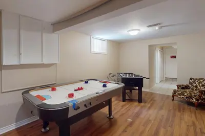 a room with a pool table in the middle of a room at Wavy Daze in Wasaga Beach