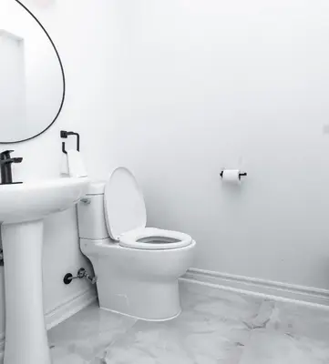 a white bathroom with a toilet and a sink at Vacation Home in Vaughan in Vaughan