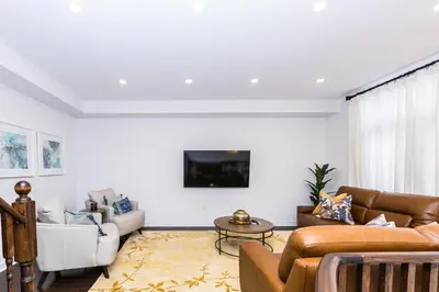 a living room with couches and a tv on a wall at Vacation Home in Vaughan in Vaughan