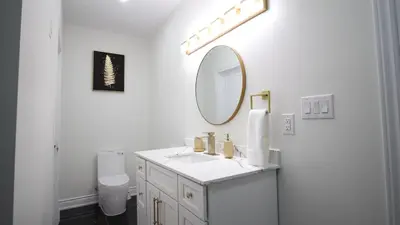 a white bathroom with a sink and a mirror at Beautiful Separate Unit, GrandRiver & Kiwanis Park in Kitchener
